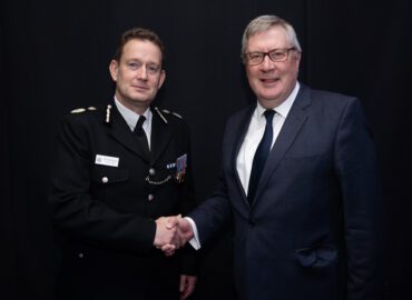 Chief Constable BJ Harrington shaking the hand of PFCC Roger Hirst. They are both smiling.